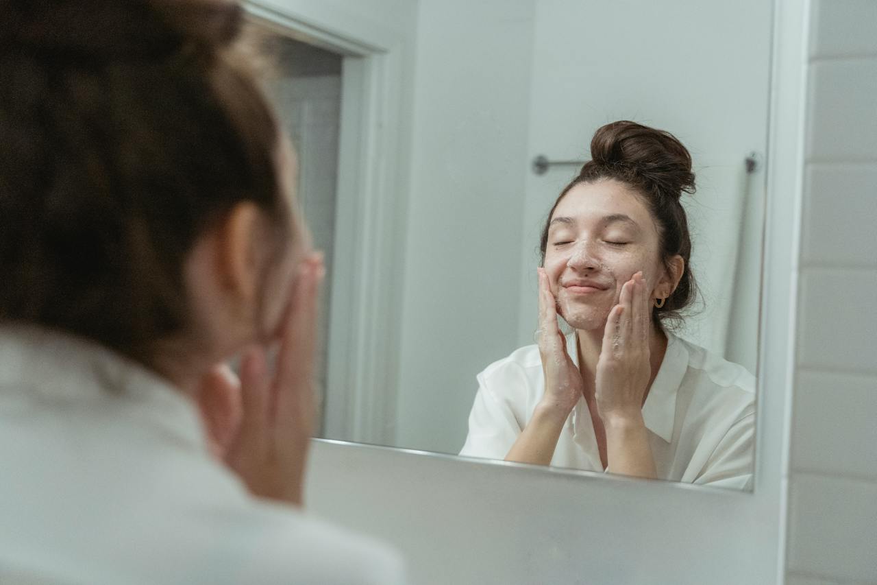 girl washing face in mirror