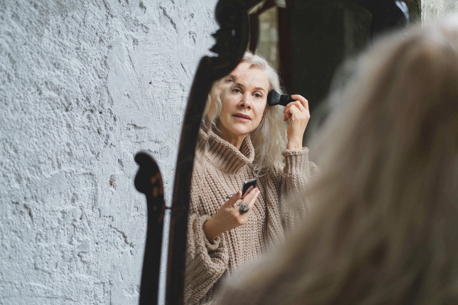 Older white woman applying makeup 