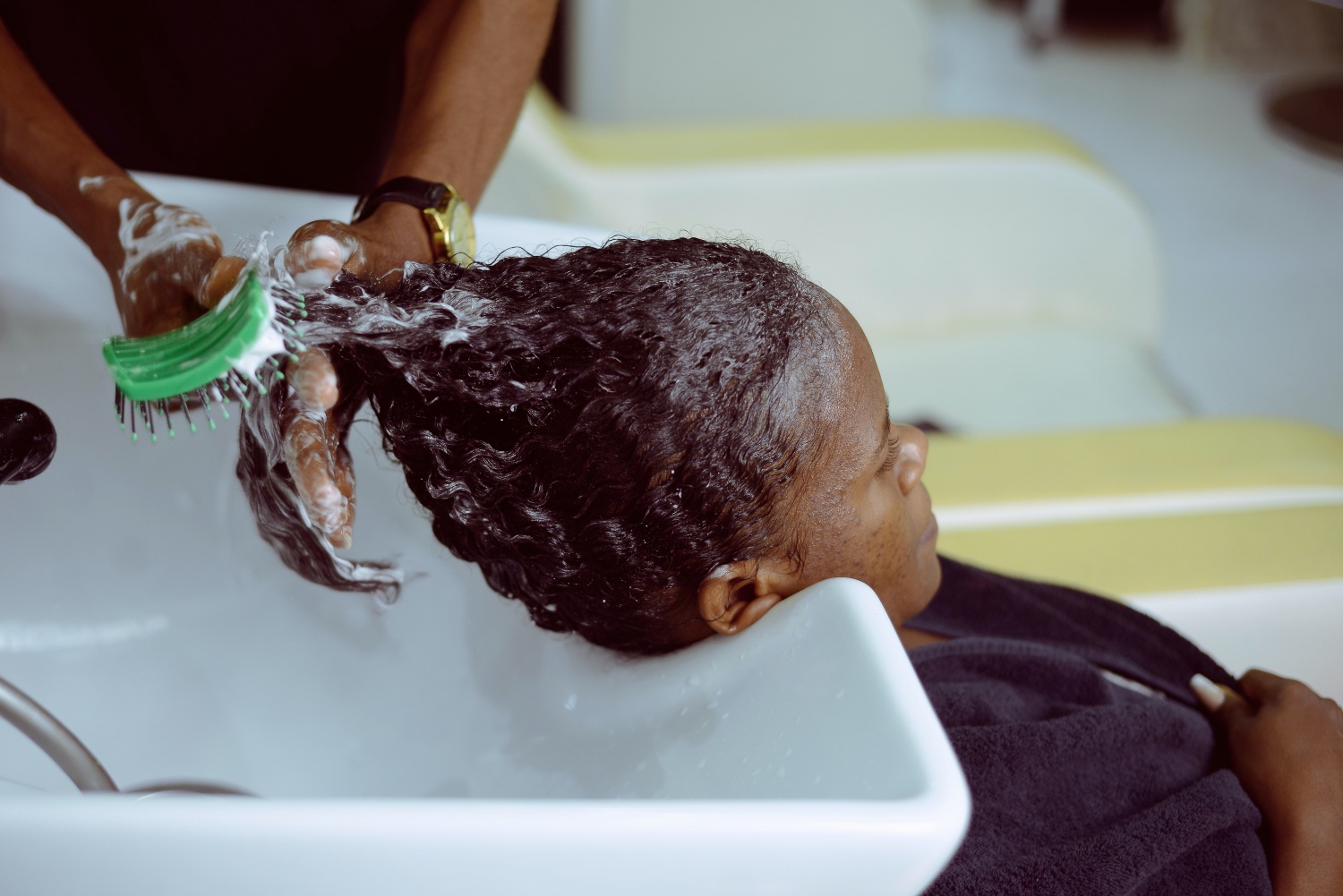 Black woman getting hair washed 