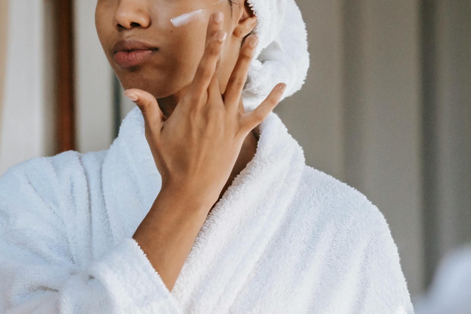 woman applying cream on face 