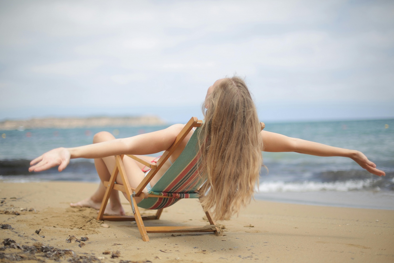 Blonde girl on the beach with wavy hair 