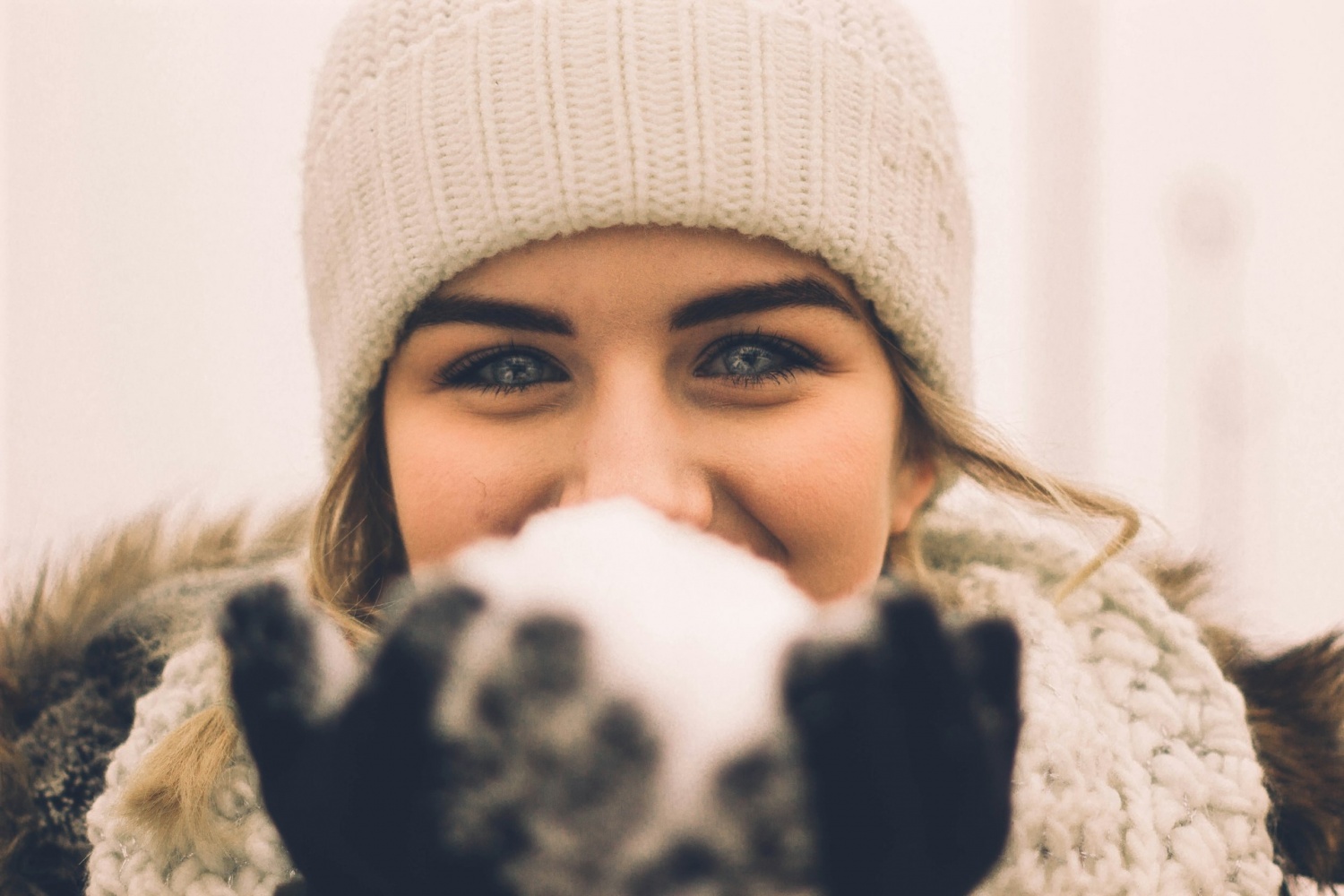 girl with blue eyes holding a snowball