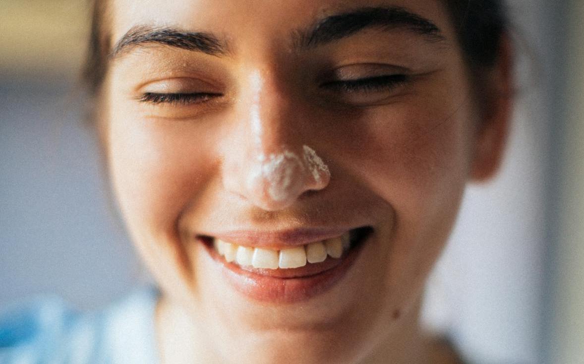 woman with face lotion on the nose
