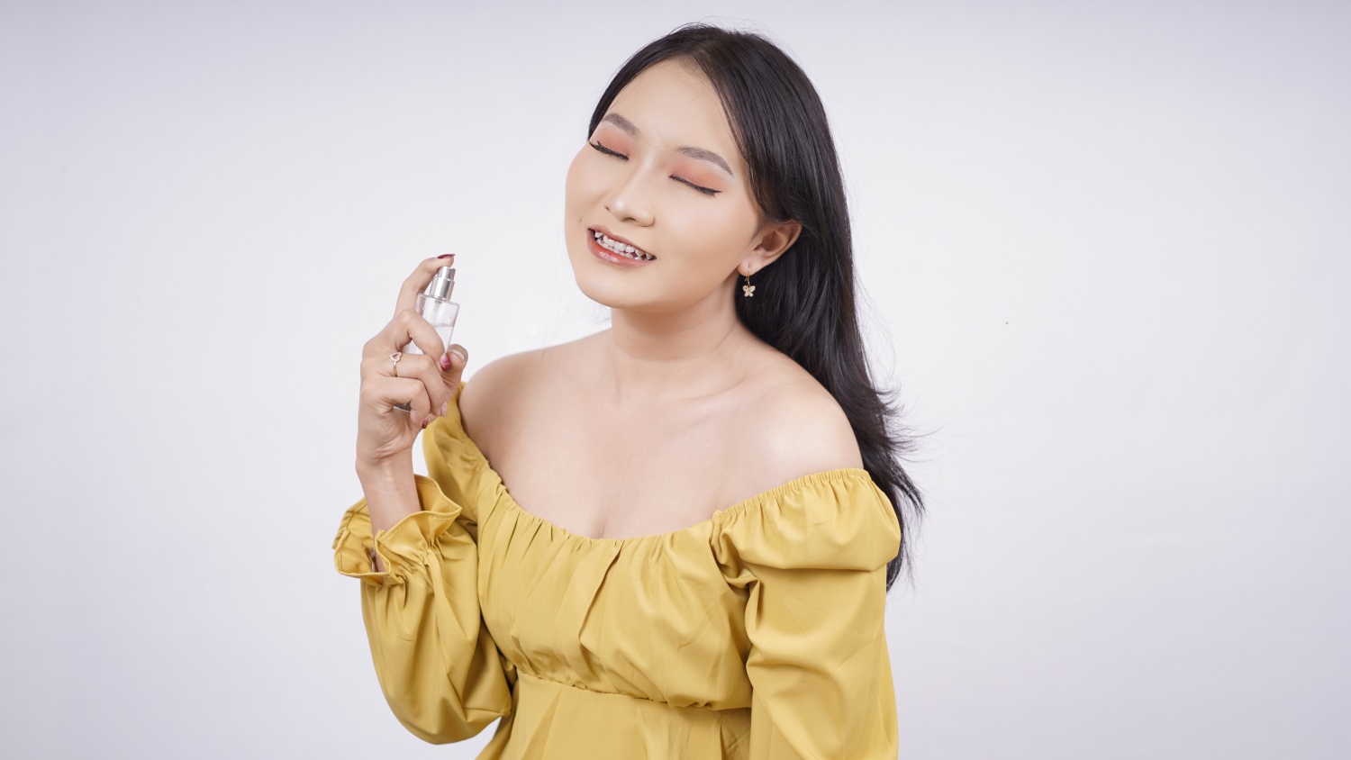 Asian woman spraying perfume 