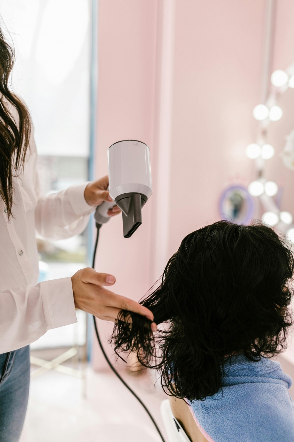 woman blow drying another woman's hair 