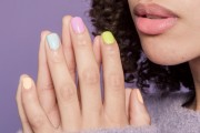 Women with peach, blue, purple and yellow nails 
