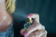 A white woman spraying perfume 